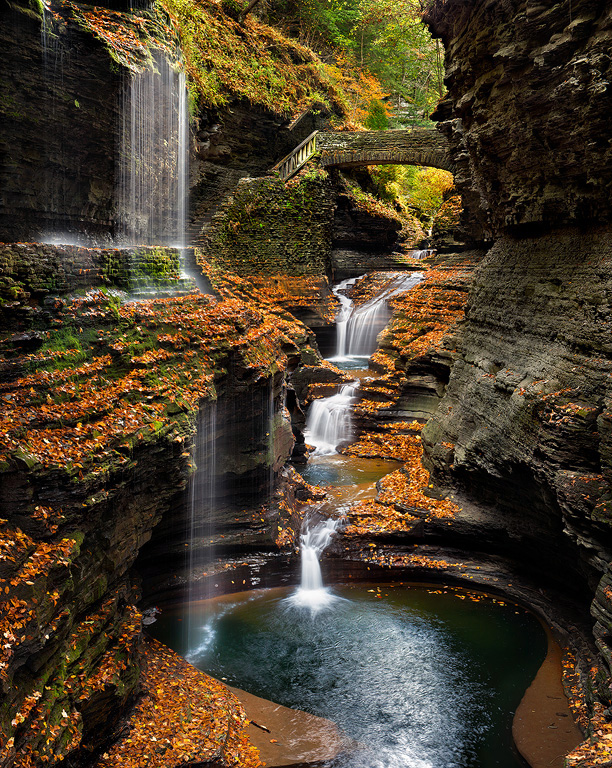 Falls surrounded by peak fall color; ideal conditions highlight saturated leaves and reflections.
